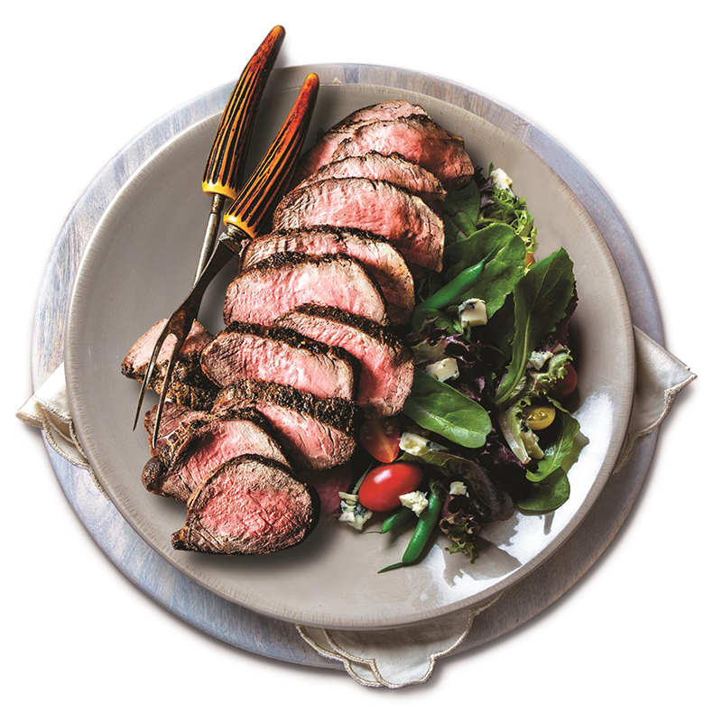 Sirloin steak sliced on plate with fresh salad